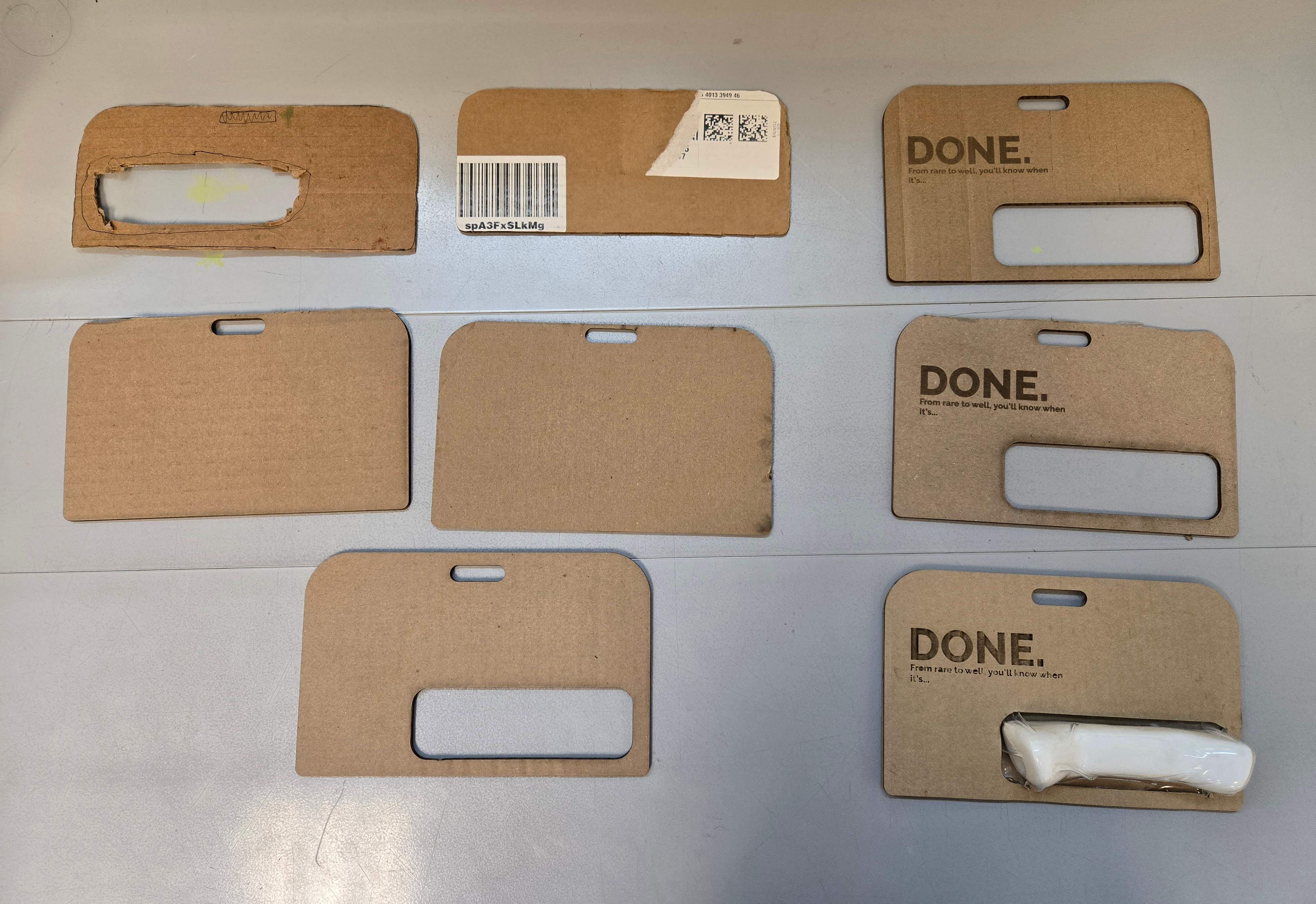 DONE. packaging prototypes — seven cardboard hang card iterations showing window cutout and proportion progression