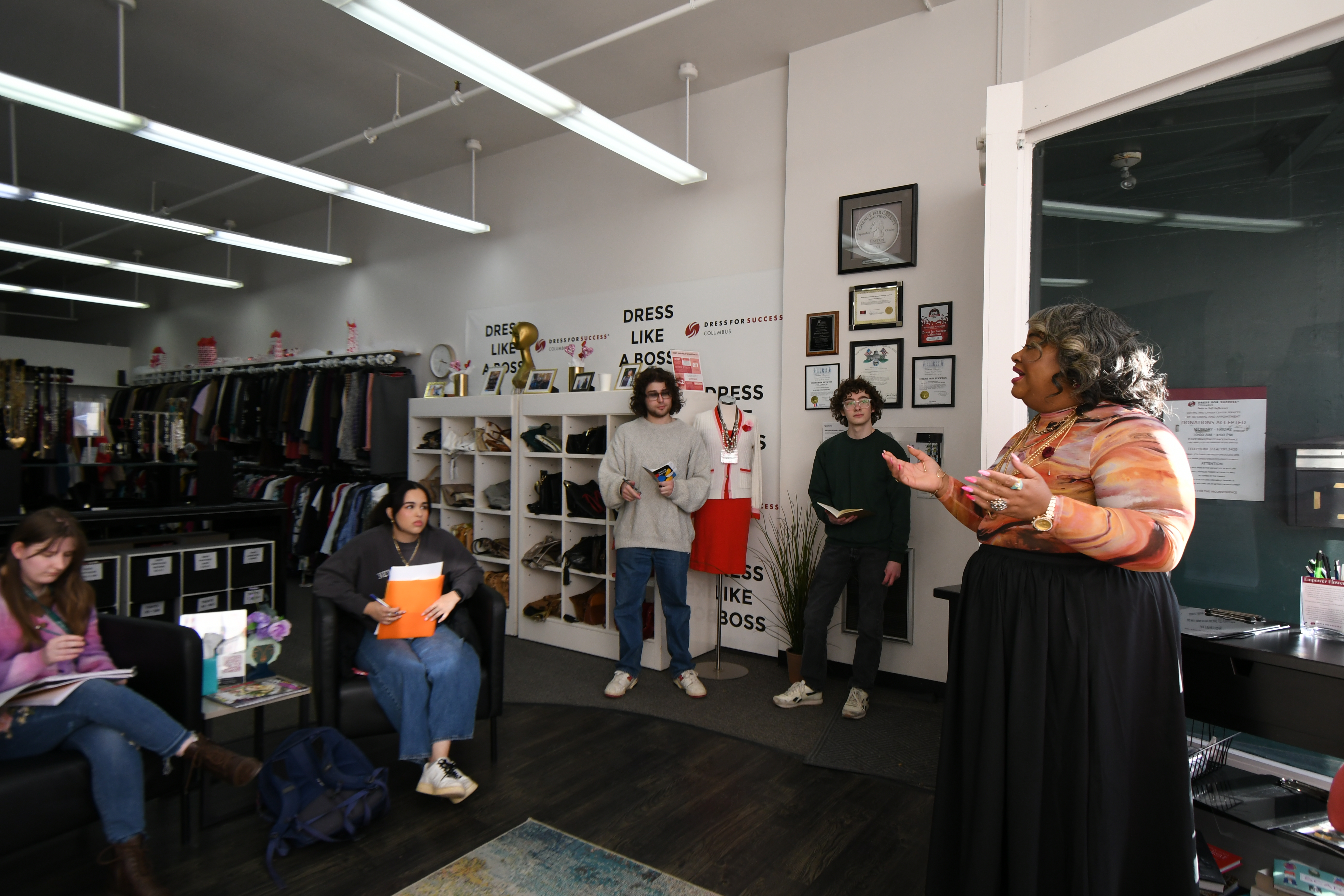 Dress for Success Columbus — research team around a table in the fitting area, fitting room lights visible in the background