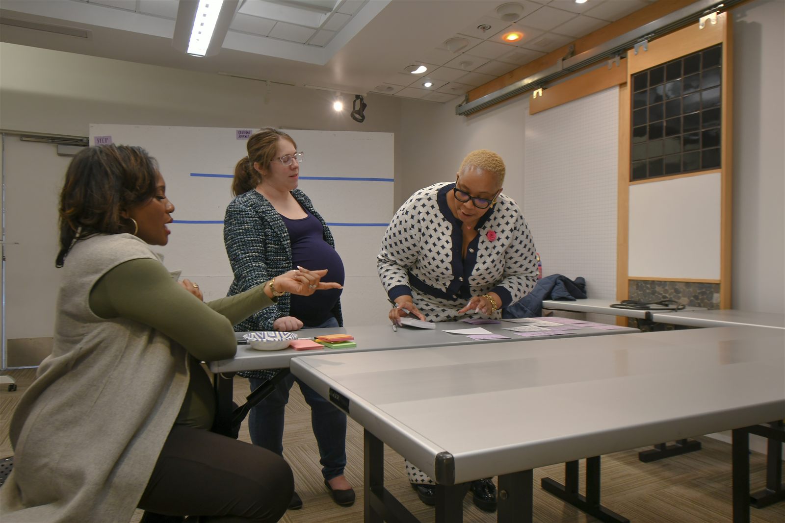 Small group collaboration — three participants working through synthesis at a table